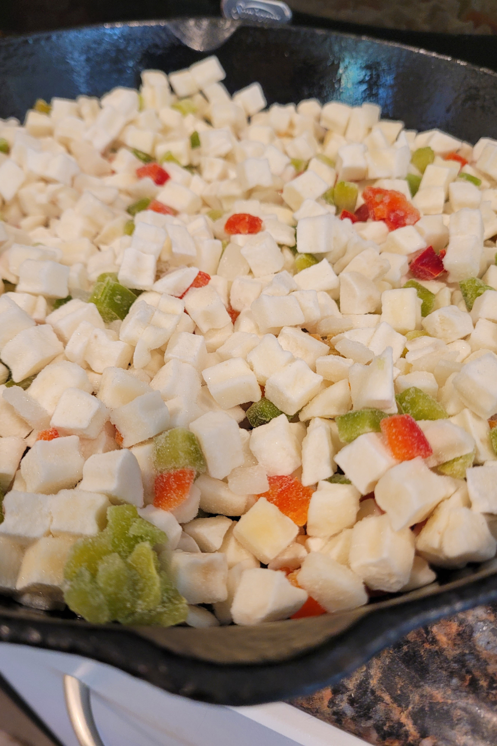 Image illustrates cheese potato casserole in a cast-iron skillet.
