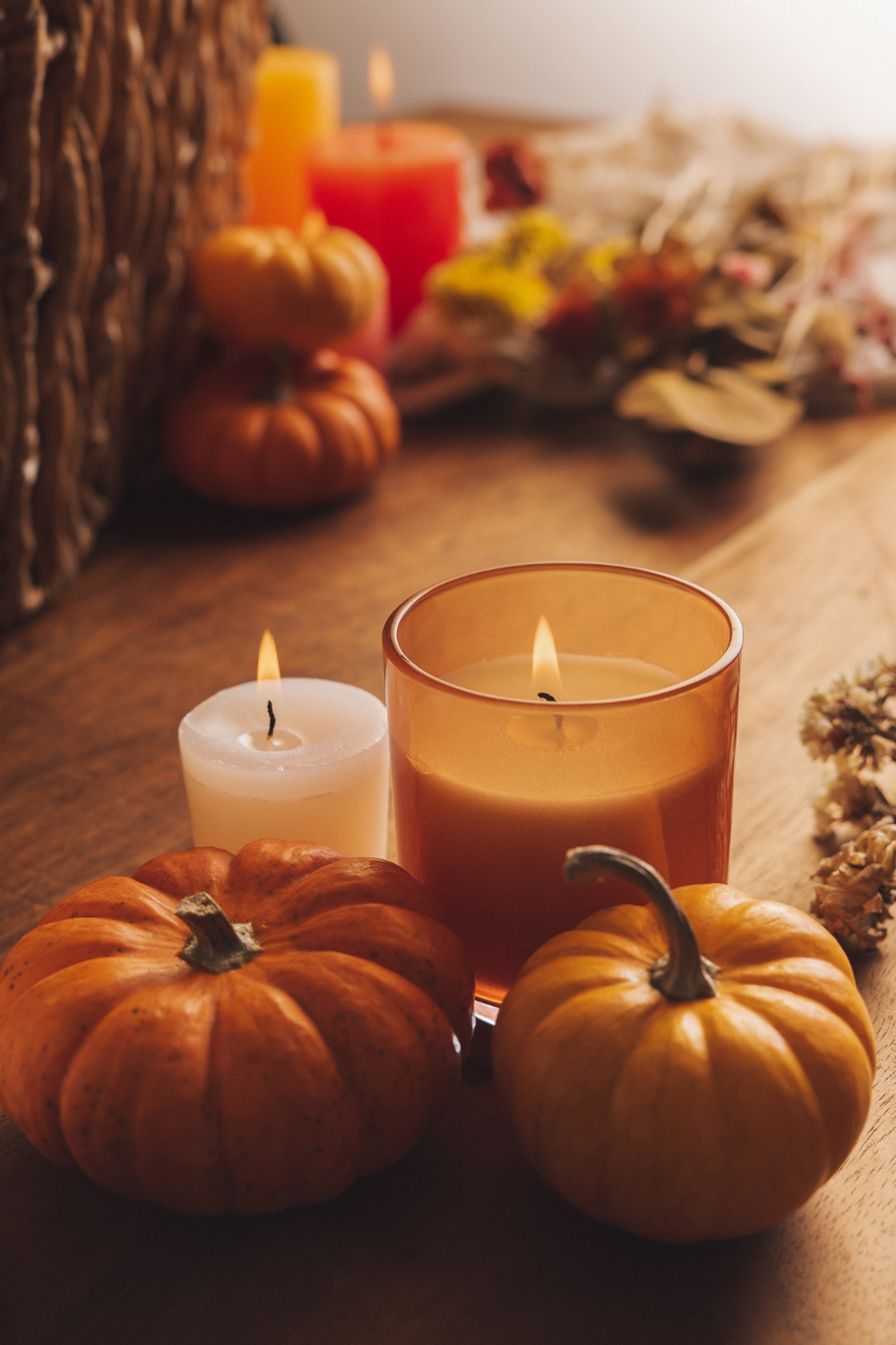 Image illustrates fall candles and pumpkins for how to prep your home for chily fall nights.