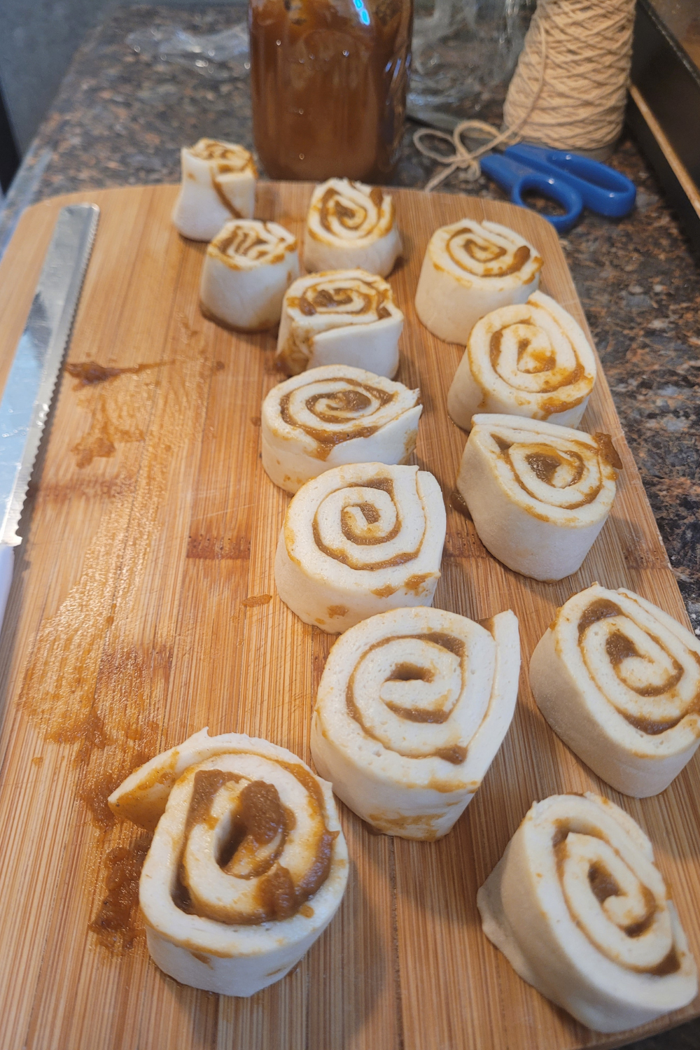 Image illustrates sourdough pumpkin shaped cinnamon rolls.