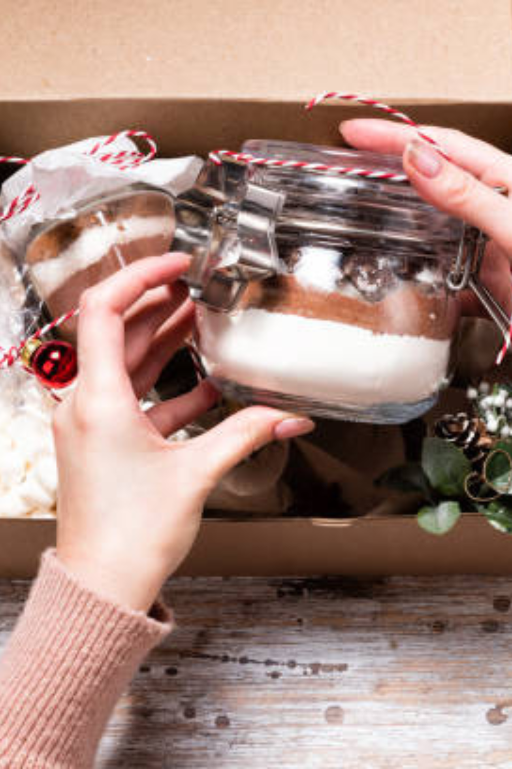 Image illustrates hot cocoa mix in a jar for handmade Christmas gifts.
