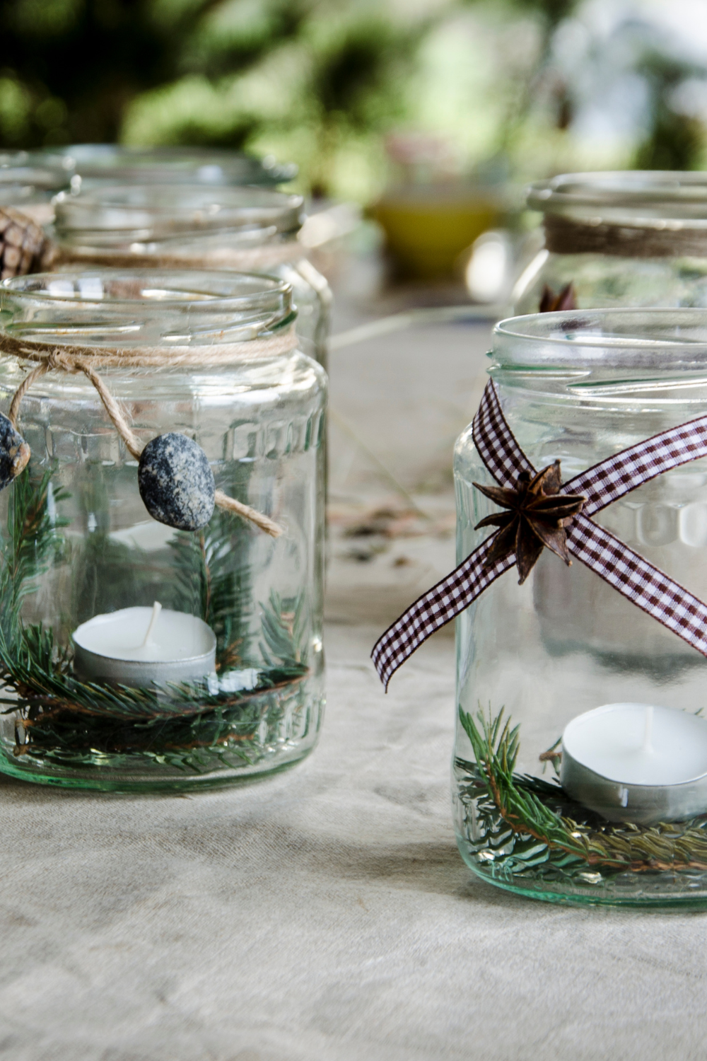 Image illustrates candlelit Mason jar lanterns for handmade Christmas gifts.