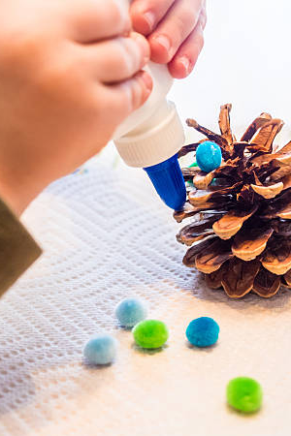 Image illustrates pinecone and pom-pom Christmas crafts for easy Christmas crafts for kids.