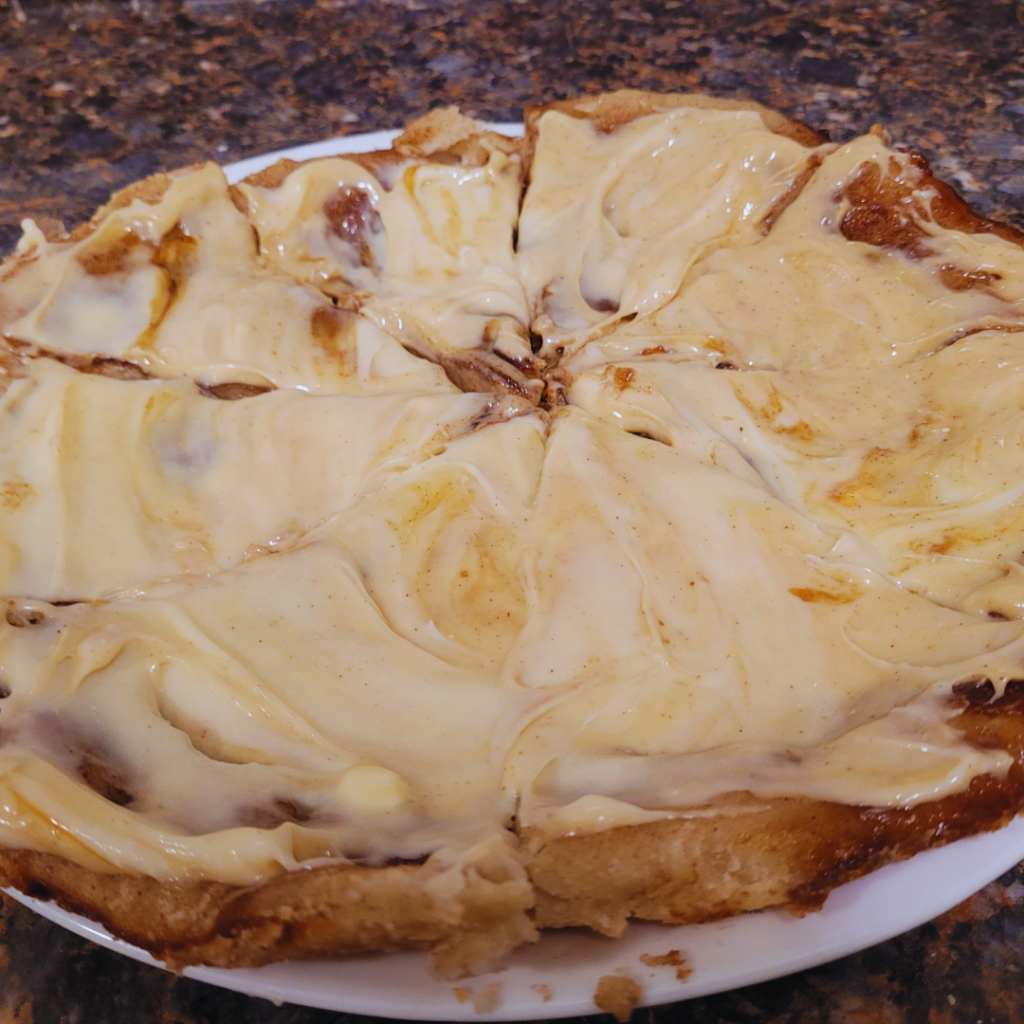 Image illustrates cinnamon roll pizza.